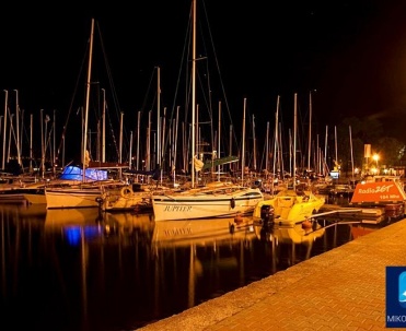 Żagl&oacute;wka na tle zachodu słońca &ndash; Mikołajki wieczorową porą