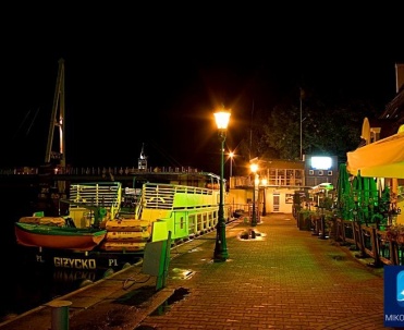 Port w Mikołajkach o zmroku &ndash; nocne światła nad wodą